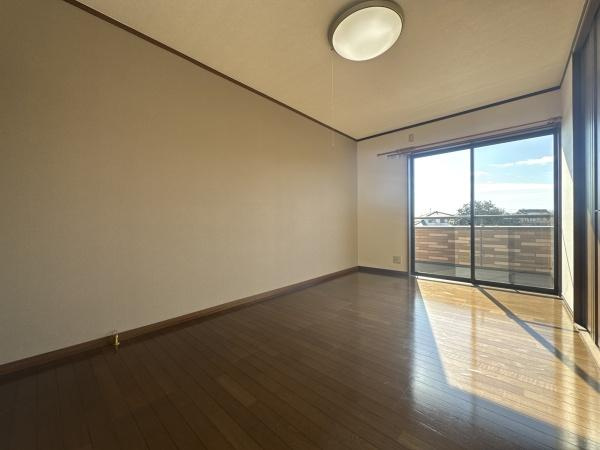 大字常行　中古の洋室|バルコニーに面した大きな窓からたっぷりの陽射しが室内に差し込みます。床は木目調で落ち着いた雰囲気です。照明器具も備え付けられており使いやすい洋室です。壁面が広く家具の配置もしやすい造りとなっています。