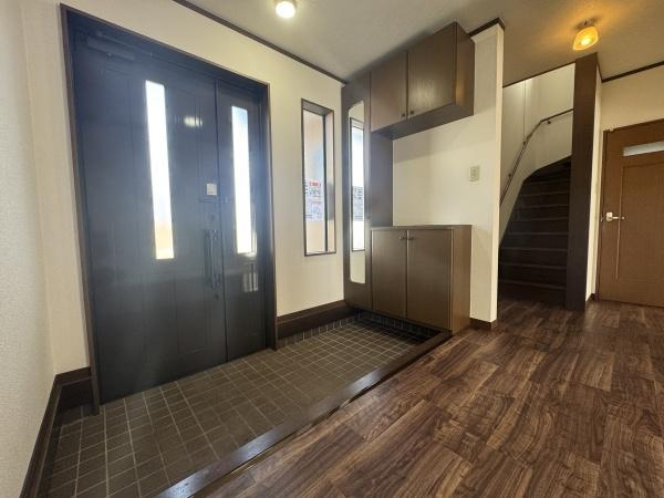 大字常行　中古の玄関|玄関は広々としたスペースが確保されており開放的な印象です。収納も豊富で整理整頓がしやすいです。自然光が差し込み明るい雰囲気に仕上がっています。落ち着きのある色合いの床材が調和しています。