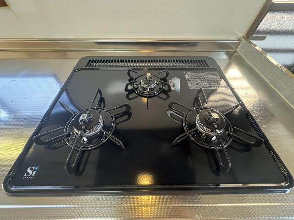 大字常行　中古のキッチン|ガスコンロはシンプルで使いやすい3口タイプです。掃除がしやすいフラットなデザインになっています。ステンレスの天板が清潔感を演出しています。キッチンの設備がしっかり整っています。