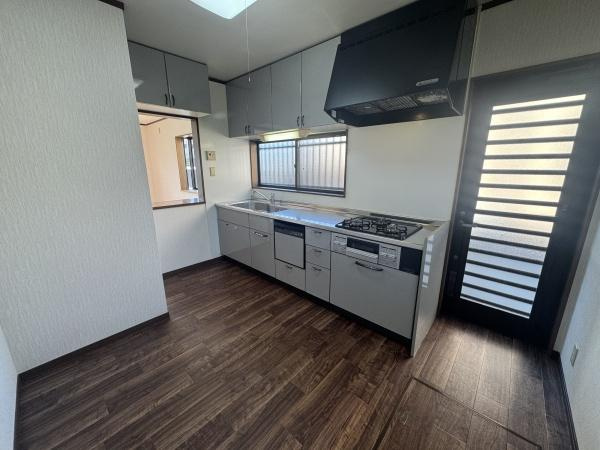 大字常行　中古のキッチン|窓からの採光があり室内が明るく感じられます。収納スペースも豊富で整理がしやすいです。キッチン全体がシンプルで清潔感があります。床材が落ち着いた雰囲気を演出しています。