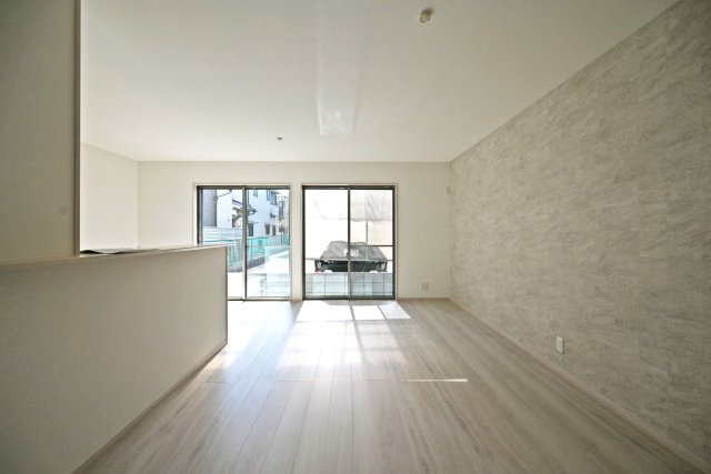 尼崎市稲葉荘1丁目新築一戸建て│3LDK+駐車1台可（ビルトインガレージ）の居間・リビング|ダイニングからリビングに向かって撮影した写真です。リビング側に大きく開けた窓から明るい光が差し込んでいます。