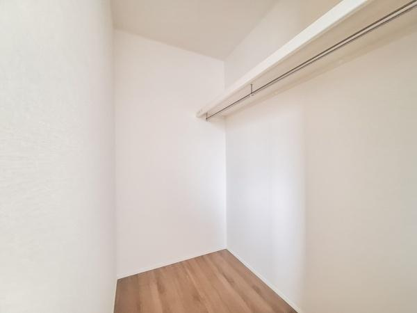 宗方台西1期1号棟の収納|広々とした収納スペースが確保されています。天井まで伸びるハンガーパイプ付きで衣類の整理にも便利です。シンプルな内装で使いやすい空間になっています。床は木目調で清潔感があります。