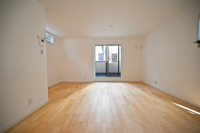 尼崎市大庄北1丁目新築戸建の居間・リビング|ダイニング側からリビングに向かって撮影した写真です。南側に大きく開けた窓から明るい陽射しが差しこみます。