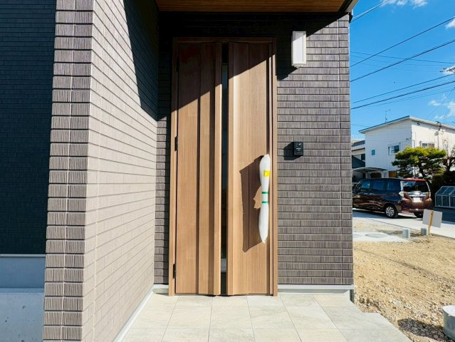 土佐市高岡町乙　Ａ号地の玄関|木目の玄関ドアが映える、上質感のある佇まい。