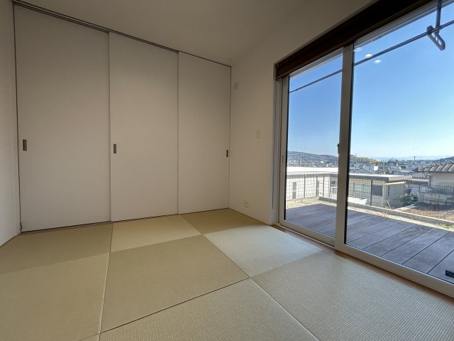 住み心地まで デザインされた家　熊本県熊本市北区高平の和室|廊下と仕切れる4.5畳の和室。大きな窓から美しい眺望を楽しめます。壁面収納では、掃除機の充電も可能。