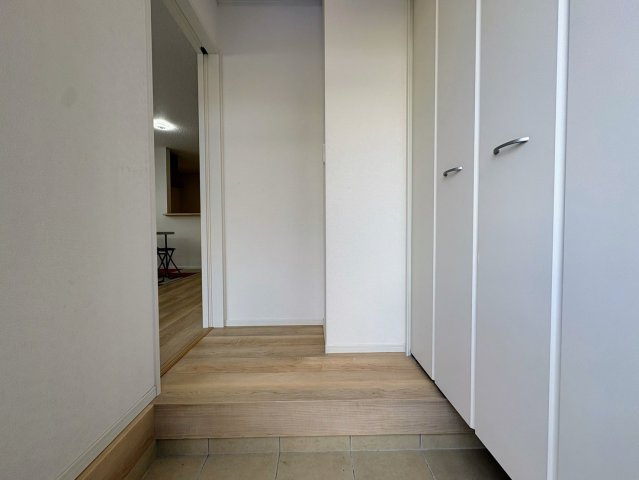 クレイドルガーデン那覇市識名 第３・２号棟の玄関|玄関の上がり框からリビングと階段へつづく廊下