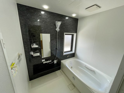 【浴室】 | 【中古戸建】東根市本丸東 | 黒い壁がアクセントになった浴室です。広々としていて、ゆっくりとお湯につかりながら一日の疲れを癒せそうですね♪