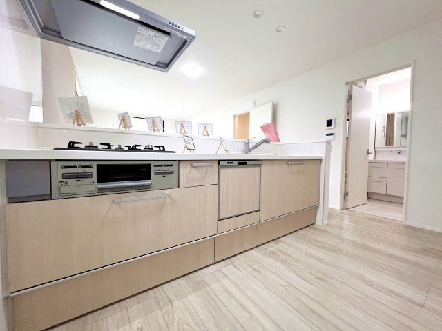 足立区西伊興１丁目　新築分譲住宅　全17棟のキッチン|【システムキッチン】豊富な収納はもちろん、大型シンクに３口グリル付きコンロ・浄水器など使いやすさ重視の対面式システムキッチン。ご家族と楽しく会話をしながら料理もできます♪※写真は施工例です。