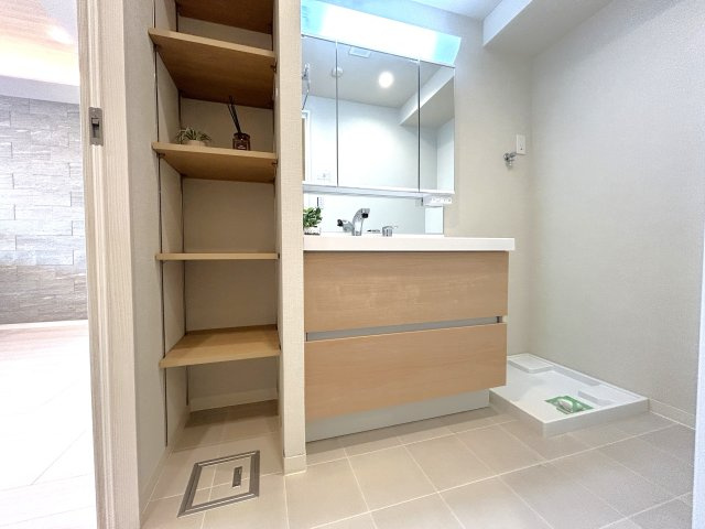 シティインデックス王子の洗面所|一日の始まりと終わりを心地よく演出してくれる、多彩な機能が備えられたパウダールーム。心地よいリフレッシュ空間です。大きく見やすい三面鏡で清潔感ある洗面台は、身だしなみチェックや肌のお手入れに。