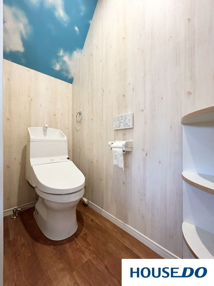 中古戸建　足利山川町のトイレ|天井に広がる鮮やかな青空模様のアクセントクロスが、開放感と明るさを演出するトイレ。毎日使う場所だからこそ、一歩入るだけで気分がリフレッシュできるようなこだわりを詰め込みました☆