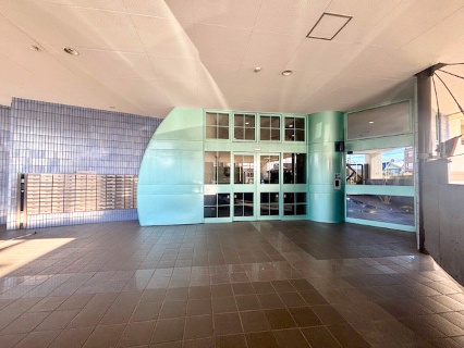 プルミエール入間シティのエントランス|沿道からアプローチを通ってエントランス入口になりますから、不審者には敷居が高いです。オートロックなので、お子様1人の留守番も安心。明るいエントランスです。（2025年12月撮影）