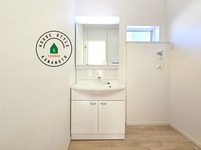 合志市野々島第3-1棟（1号棟）の独立洗面台|毎日使うものだから清潔な空間を保ちたい水回り。洗面にはそんな願いを解消させてくれる収納アイデアが満載です。三面鏡の裏側にはキャビネットが現れ小物から背の高い物まで収納できます。