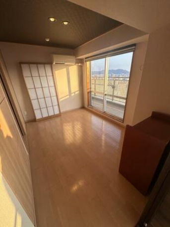 高知市九反田　開放的な眺望の中古マンションの洋室|バルコニーに面した居室。景色と風を感じる心地よさ