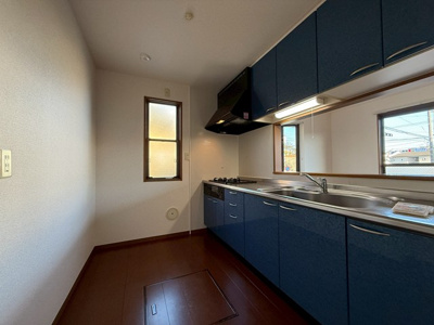 【キッチン】 | パレスガーデンA | 落ち着いた青を基調としたシステムキッチンです！窓があるので換気もOK♪場所を取るお鍋やお皿もたっぷり収納できてお料理がはかどります！