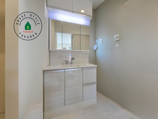 糟屋郡志免町桜丘1丁目第1-2棟（2号棟）の内観：施工例|毎日使うものだから清潔な空間を保ちたい水回り。洗面にはそんな願いを解消させてくれる収納アイデアが満載です。三面鏡の裏側にはキャビネットが現れ小物から背の高い物まで収納できます。