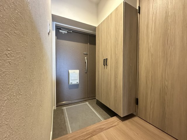 横浜・大口ハウスの玄関|大型シューズボックスもある玄関口なのに圧迫感のないナチュラルな木目調の玄関となっています。