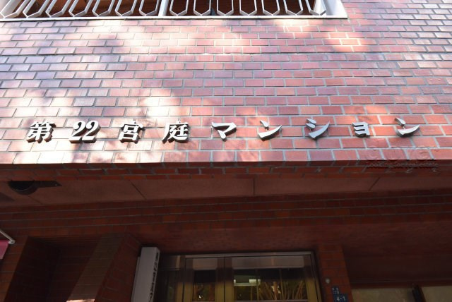 【現況写真】 | 第22宮庭マンション | マンションの入り口に掲げられた、建物名称の表示部分。不動産業界ではこれを「館銘板」と呼びます。～即日のご見学可能～　お問合せはお気軽にどうぞ。
