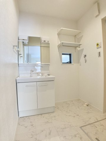 高知市介良乙　新築一戸建て⑰の独立洗面台|収納棚付きの洗面脱衣所。洗濯動線もスムーズで毎日の家事が快適。