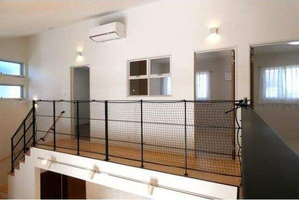 HT久原4号地の内装|解放感のある吹き抜けと室内窓が特徴的です。上階へ続く階段や手すり付きの廊下が安全に配慮されています。ナチュラルカラーの床と白い壁が明るい印象を与えます。窓からの採光で室内がより開放的に感じられます。