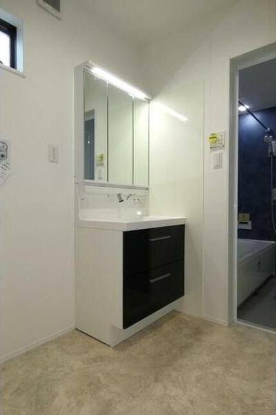 HT久原2号地の独立洗面台|洗練されたデザインの洗面台が空間を引き締めています。明るい照明付きミラーが毎日の身支度をサポートします。収納力のある引き出しが備わっていて使いやすさも魅力です。