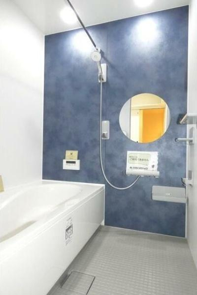 HT久原2号地の浴室|シンプルで落ち着いた色合いのバスルームです。丸い鏡がアクセントになっており空間に広がりを感じられます。壁面のカラーが個性的で清潔感のある雰囲気を演出しています。ゆったりとした浴槽が印象的です。