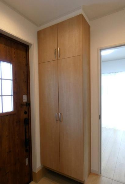 HT久原1号地の玄関|玄関には高さのある収納が設置されています。木目調のデザインで空間に調和しています。横幅がしっかりと確保されており玄関まわりをすっきりと見せてくれます。室内への動線も良好です。