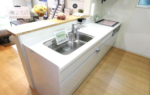 HT久原1号地のキッチン|明るく開放的なキッチンです。十分な作業スペースがありすっきりとしたデザインが魅力です。収納スペースも豊富でお手入れしやすい仕様となっています。カウンター付きで使い勝手に優れています。