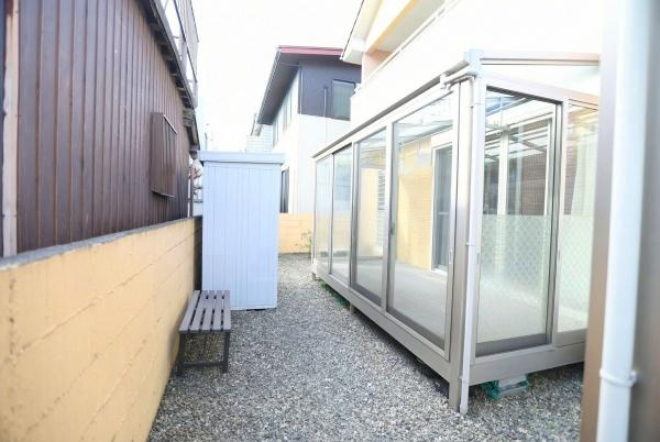 城東町　戸建てのその他|ガラス張りのサンルームが設置されており気軽に使えるスペースです。砂利敷きのお庭でメンテナンスも簡単です。物置も設置され収納スペースが確保されています。
