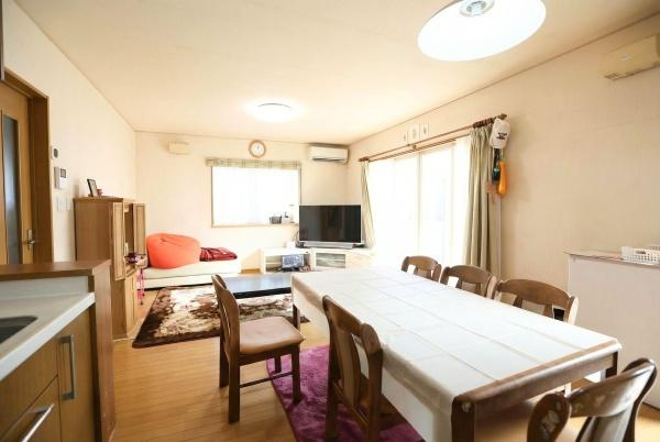 城東町　戸建ての居間・リビング|リビングは大きな窓から光が入る明るい空間です。テーブルやテレビスペースもゆったりと配置されています。壁際の収納や落ち着いた色合いのインテリアも特徴的です。