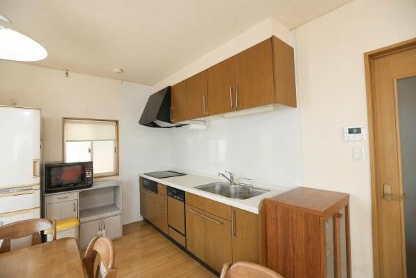 城東町　戸建てのキッチン|木目調のキッチンキャビネットが印象的です。窓のある配置で明るさを感じられます。収納スペースも豊富に確保されています。使い勝手に配慮されたキッチンスペースです。