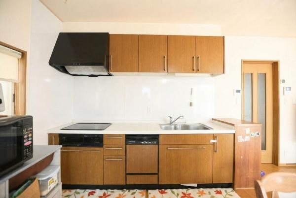 城東町　戸建てのキッチン|使い勝手を考えたシンプルなキッチンレイアウトです。木目調の扉が落ち着いた雰囲気を演出します。収納スペースも充実しており調理がスムーズに進められます。