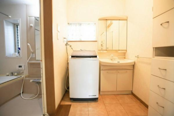 城東町　戸建ての独立洗面台|洗面台と洗濯機が並んだレイアウトで使い勝手の良い空間です。三面鏡付きの洗面化粧台が設置されています。収納スペースも確保されており日用品の整理に役立ちます。浴室へのアクセスもスムーズです。