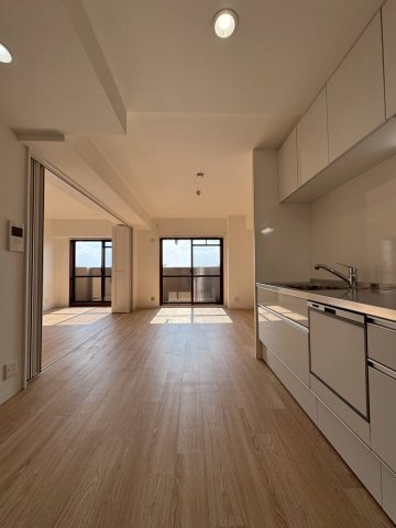 ライオンズマンション城東緑橋の居間・リビング|壁付けキッチンで収納スペースも豊富です。