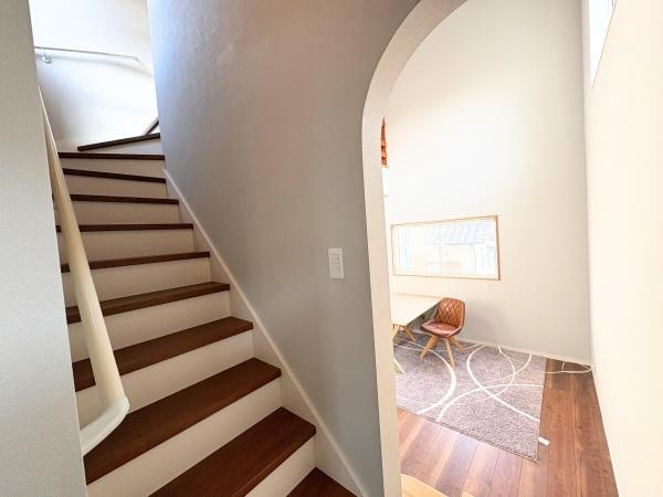 大字屋山　中古の内装|階段のデザインが直線的で空間にアクセントを加えています。アーチ状の開口部がやわらかい印象を演出します。採光も確保され全体的に明るい雰囲気です。床材のコントラストも特徴的です。