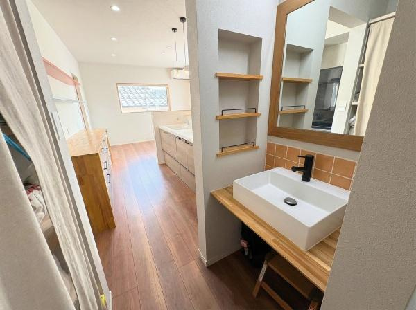 大字屋山　中古の独立洗面台|洗面台はシンプルなデザインでナチュラルな木目とアクセントタイルが調和しています。棚が多く使いやすさも重視されています。明るい空間が広がり全体が開放的な印象です。お手入れしやすい素材が使用されています。
