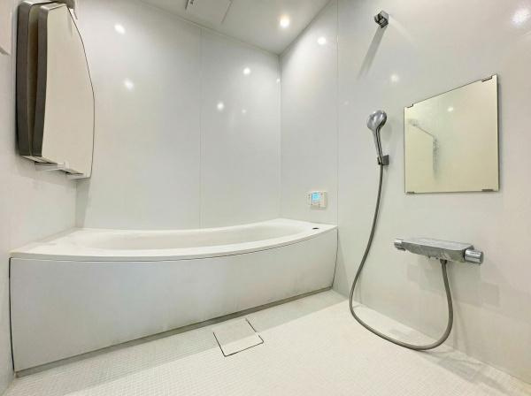 大字屋山　中古の浴室|白を基調とした室内で清潔感が漂うバスルームです。広々とした浴槽があり余裕をもって使用できます。壁面には大きめのミラーが設置されています。シャワー設備も取り付けられ使い勝手の良い空間です。