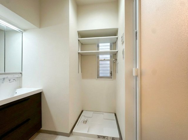 T-WOODの洗面所|大型の洗濯機を置いても余裕が感じられる脱衣スペースにはお洒落な洗面ユニットを制作。着替えやタオル、洗剤の買い置きなどリネン庫の使い方はお客様しだい。