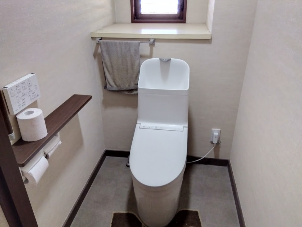 三島市谷田の中古マンションのトイレ|清潔感のある温水洗浄便座付きトイレです。操作パネルは壁付けタイプで使いやすく、毎日の生活を快適にサポートします。小窓付きのため自然換気が可能で、明るさと通風を確保できる点も嬉しいポイントですね。