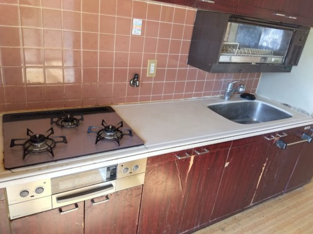 三島市谷田の中古マンションのキッチン|タイル張りの壁面が特徴的な、落ち着いた雰囲気のキッチンです。作業スペースをしっかり確保された3口コンロ付きで、同時調理もしやすい仕様です