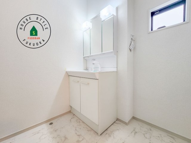 福岡市西区愛宕1丁目第3-2棟（1号棟）　の内観：施工例|毎日使うものだから清潔な空間を保ちたい水回り。洗面にはそんな願いを解消させてくれる収納アイデアが満載です。三面鏡の裏側にはキャビネットが現れ小物から背の高い物まで収納できます。