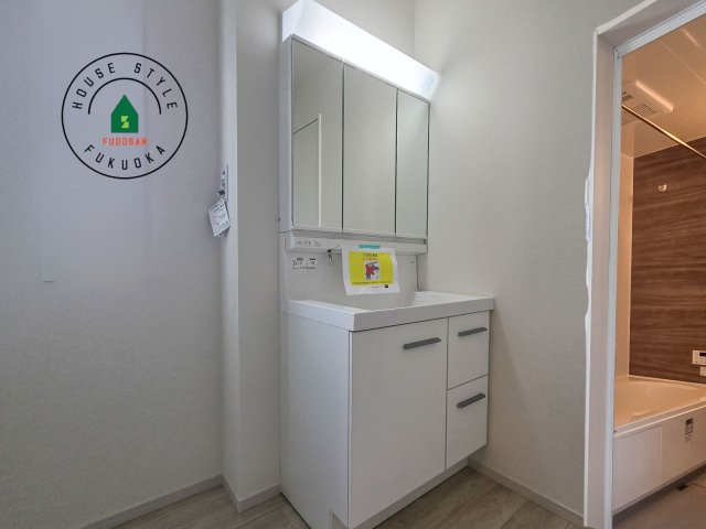 福岡市西区姪の浜1丁目第1-2棟（2号棟）　の内観：施工例|毎日使うものだから清潔な空間を保ちたい水回り。洗面にはそんな願いを解消させてくれる収納アイデアが満載です。三面鏡の裏側にはキャビネットが現れ小物から背の高い物まで収納できます。