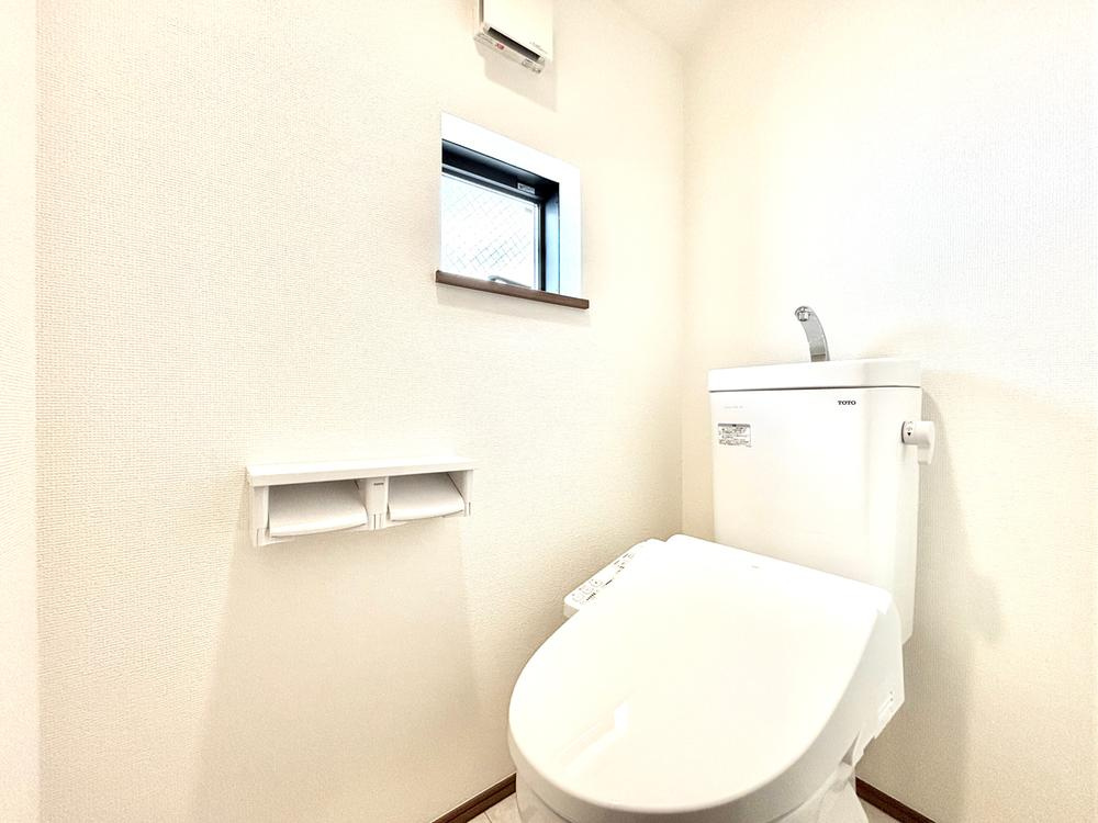 【Heartfull Town】小平栄町のトイレ|シンプルで掃除やお手入れがしやすいデザイン。背後の壁に収納棚がございますのでトイレットペーパーや掃除用品等の備品が収納可能です。