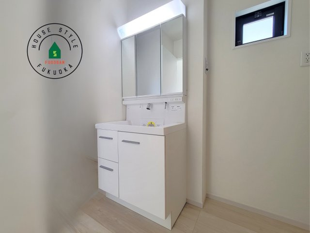 福岡市東区香椎駅東１丁目第4-1棟（１号棟）の内観：施工例|毎日使うものだから清潔な空間を保ちたい水回り。洗面にはそんな願いを解消させてくれる収納アイデアが満載です。三面鏡の裏側にはキャビネットが現れ小物から背の高い物まで収納できます。