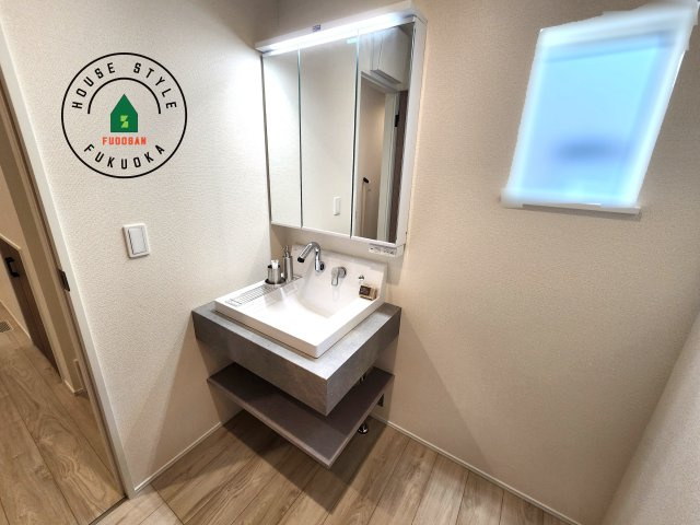 福岡市中央区笹丘２丁目第1-5棟（4号棟）の内観：施工例|毎日使うものだから清潔な空間を保ちたい水回り。洗面にはそんな願いを解消させてくれる収納アイデアが満載です。三面鏡の裏側にはキャビネットが現れ小物から背の高い物まで収納できます。