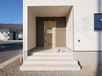 【玄関】 | 甲府市羽黒町　新築戸建 全2棟 2号棟 車3台並列駐車可能 | 広いポーチ付きの玄関