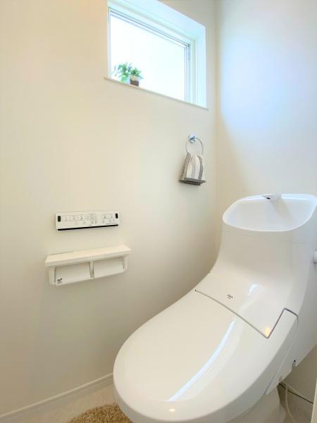 大在浜二丁目　戸建てのトイレ|明小窓から自然光が入り換気にも配慮されています。収納やペーパーホルダーもすっきりと配置されています。清潔感のあるホワイトを基調とした内装です。