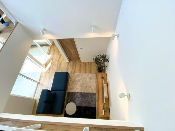 大在浜二丁目　戸建ての内装|開放感のある吹き抜けが室内に奥行きを演出しています。大きな窓から自然光がたっぷり差し込みます。木目調の床と壁が温かみを加えています。