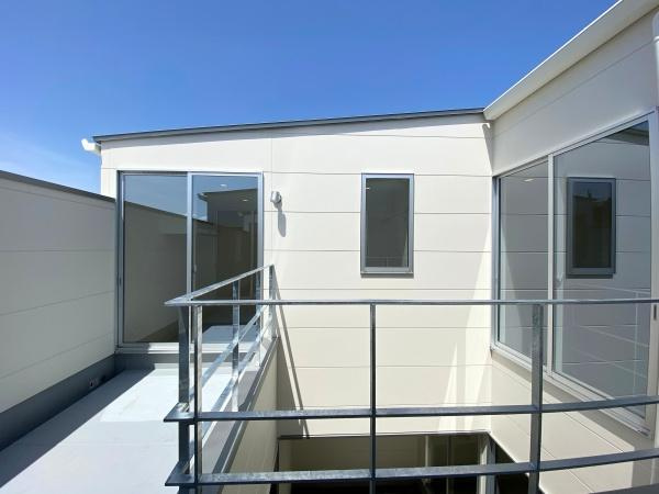 大在浜二丁目　戸建てのバルコニー|明るい日差しが差し込むバルコニーです。ガラス扉が開放的な雰囲気を演出しています。周囲が壁で囲まれた空間なのでプライバシーにも配慮されています。シンプルなデザインがすっきりとした印象を与えます。