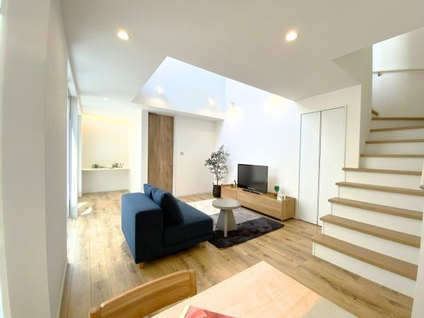 大在浜二丁目　戸建ての居間・リビング|明るいリビングは天井が高く開放的な印象です。シンプルな内装と木目調の床が落ち着いた雰囲気を演出します。階段がリビングとつながっており空間全体に広がりを感じられます。