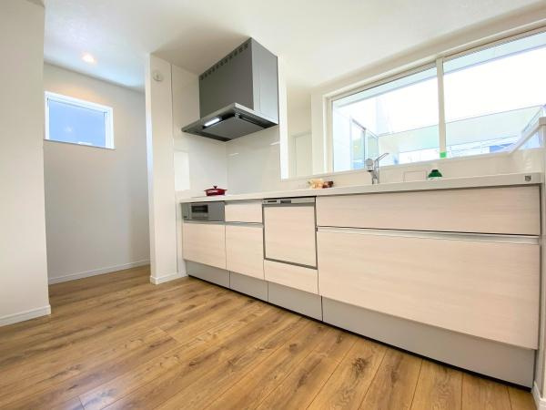 大在浜二丁目　戸建てのキッチン|ナチュラルな木目調のフローリングと明るい色合いのキッチンが調和しています。大きな窓から光が差し込む開放感のある空間です。シンプルなデザインで使いやすさにも配慮されています。